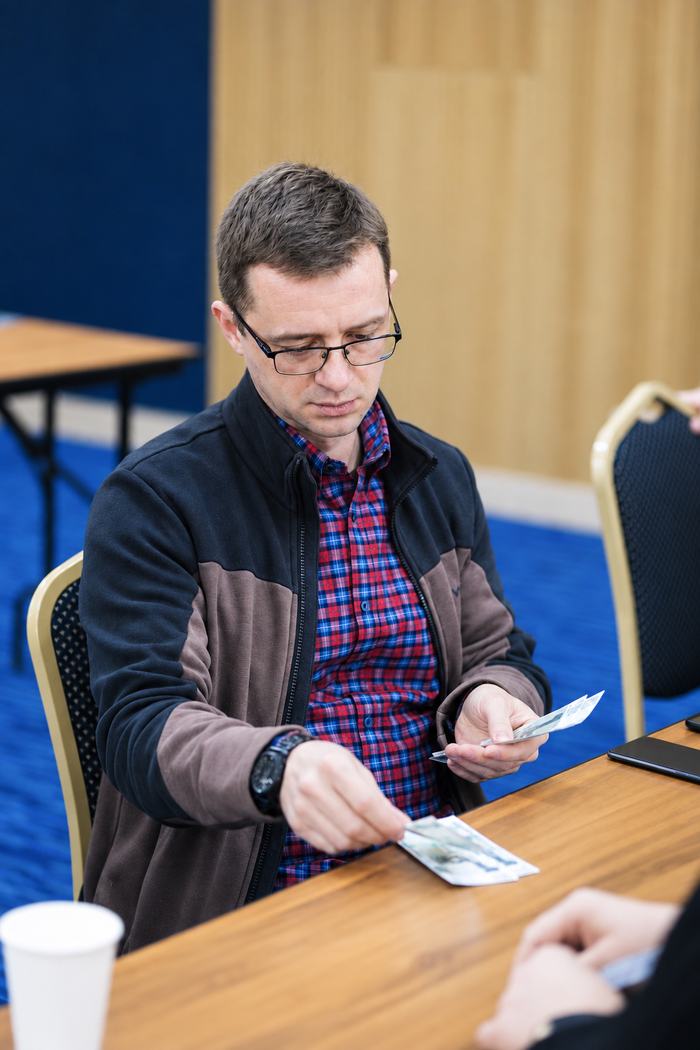 Участник выкладывает купюры на стол — момент раздела результата
